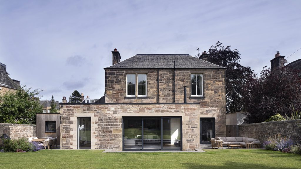 Sandstone extension with large glazing facing garden