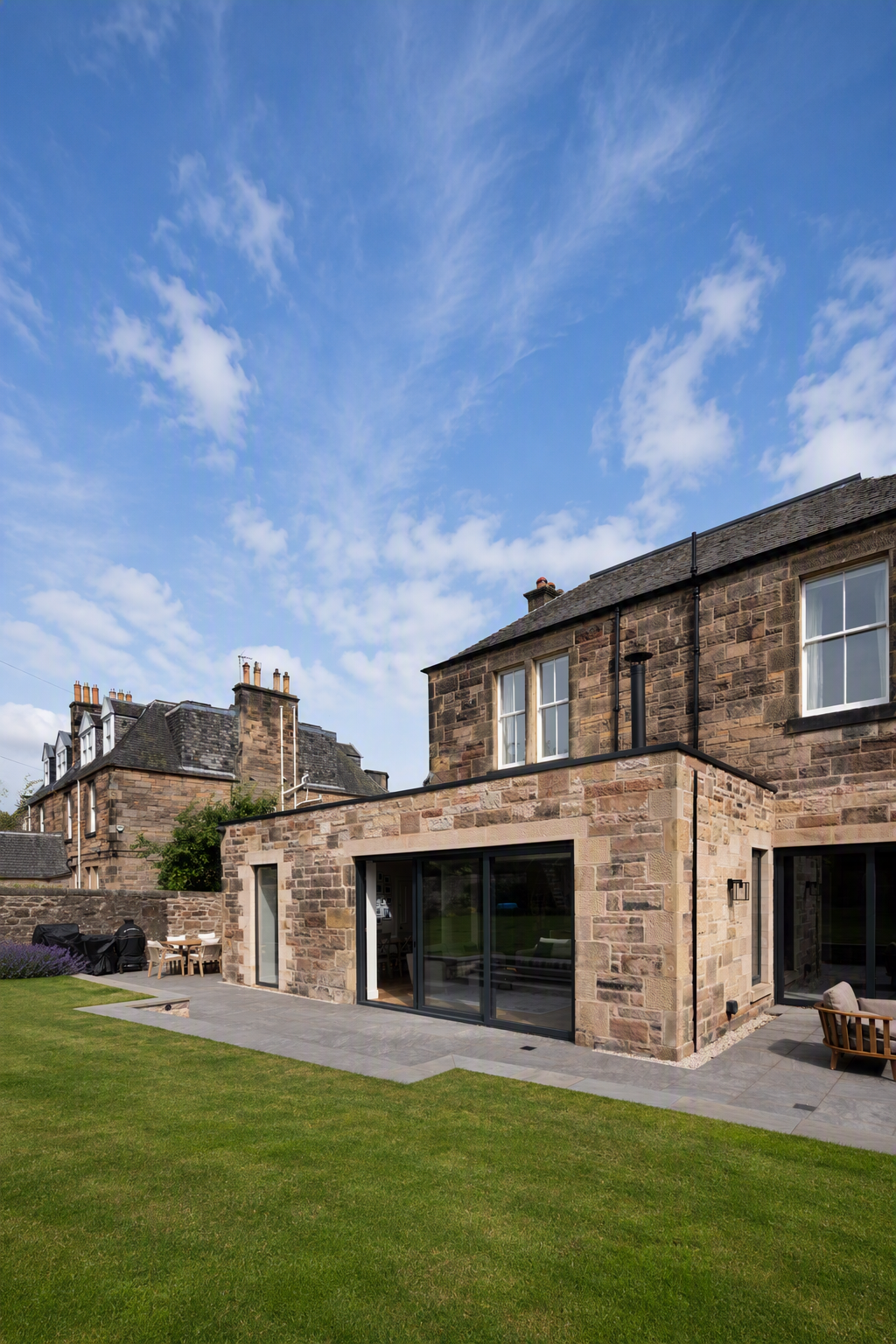 Sandstone extension with large glazing to terrace with steps to garden