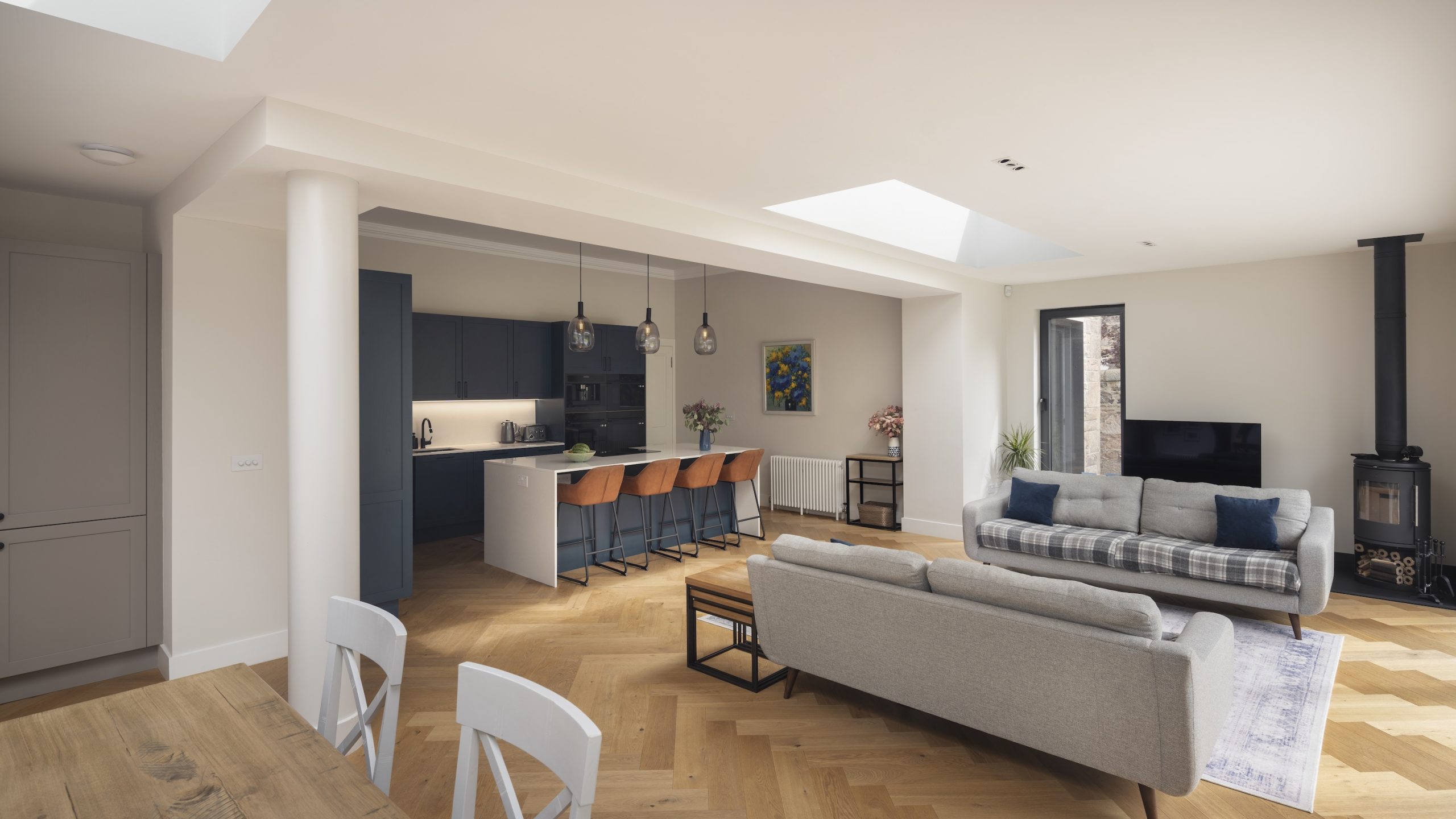 Living room with stove and kitchen in Farrow & Ball Hague Blue with large island