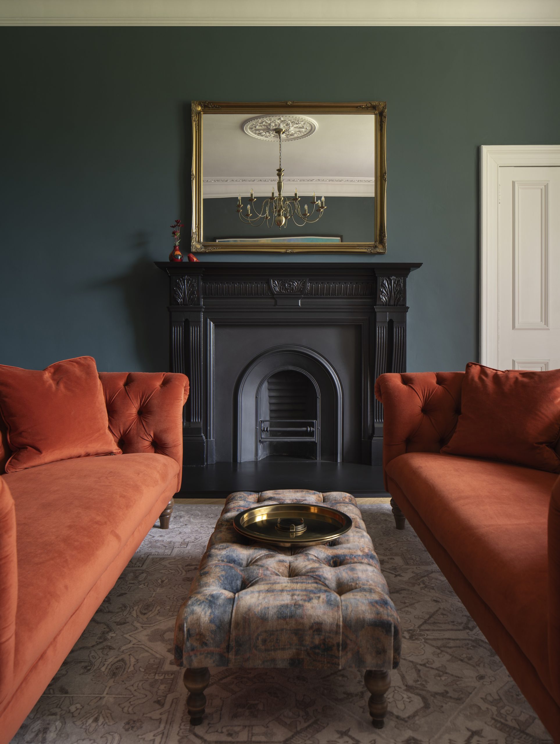 Drawing room with black fireplace and burnt orange sofas