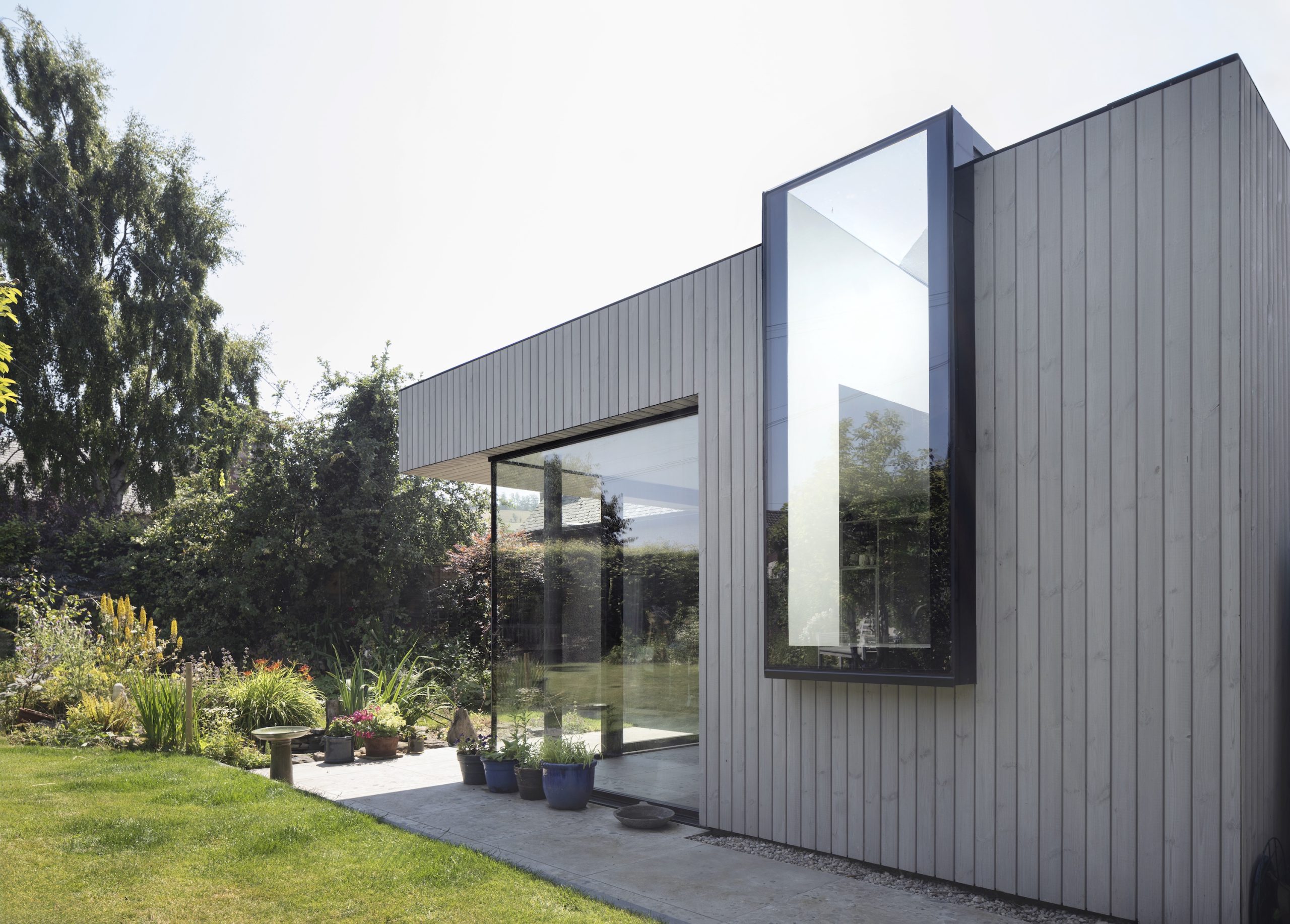 Timber clad extension with frameless corner glazing and frameless window and rooflight
