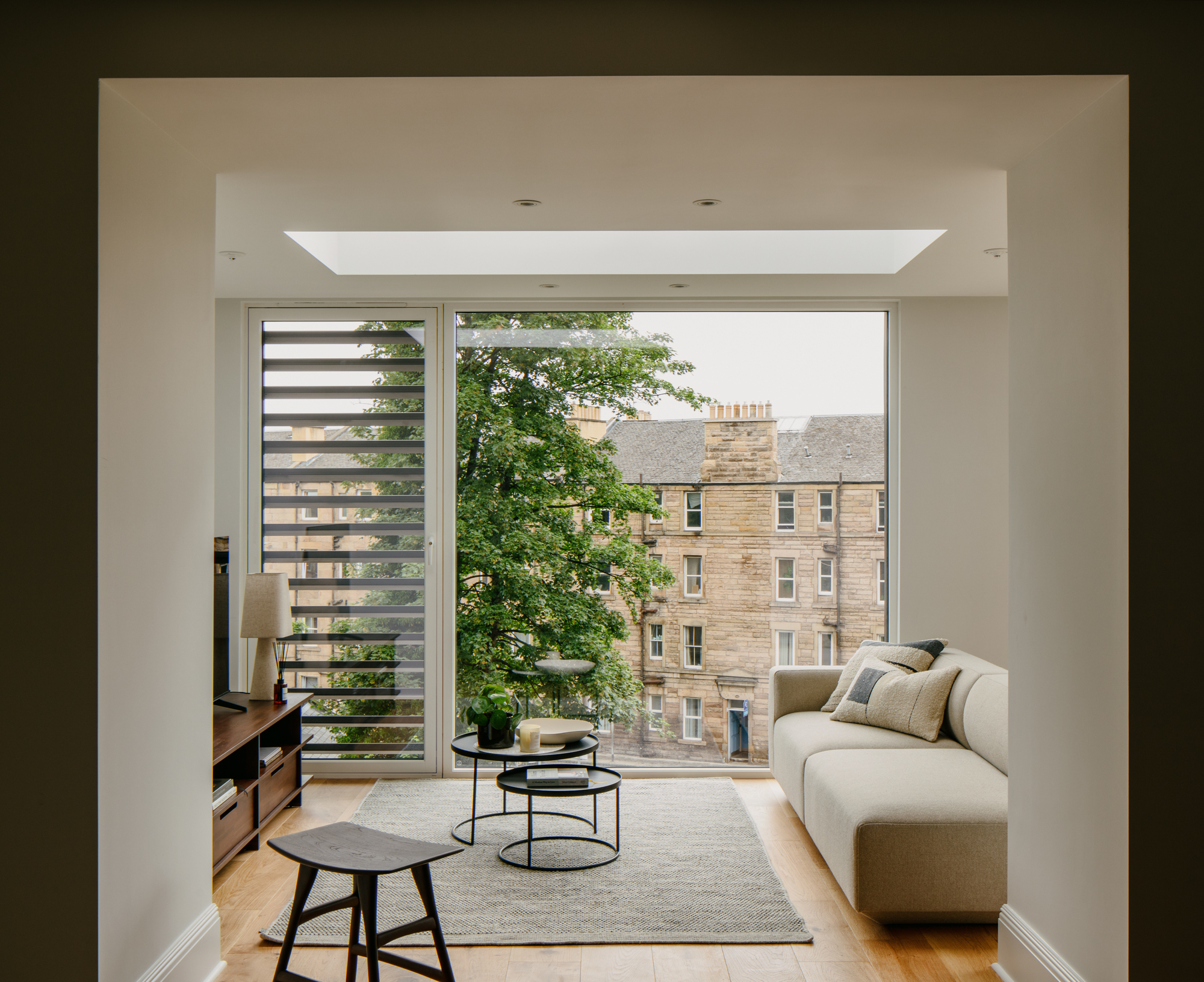 Contemporary interior with large format glazing, rooflight and louvred screen