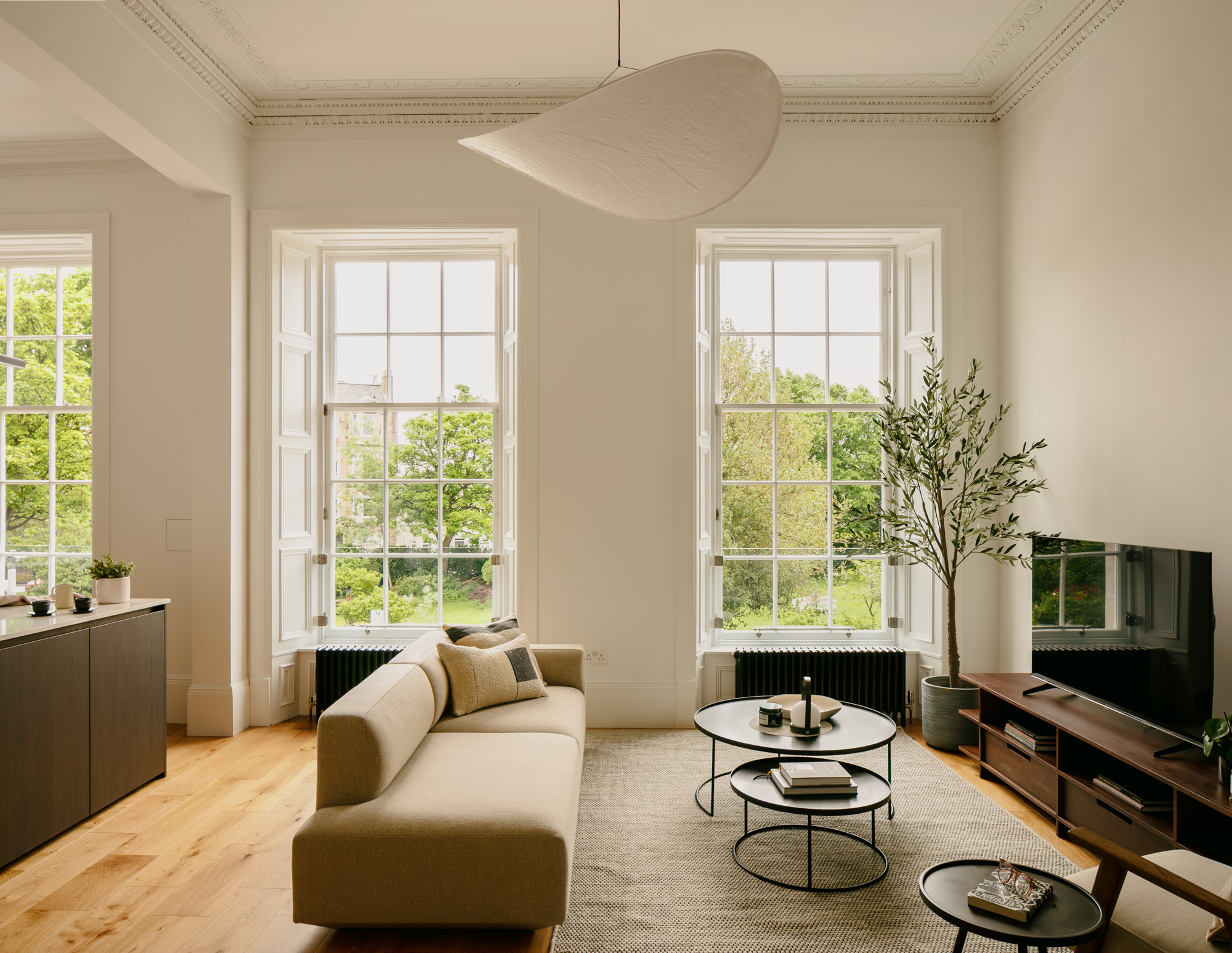 Contemporary living room in traditional townhouse with large windows and smoked oak kitchen