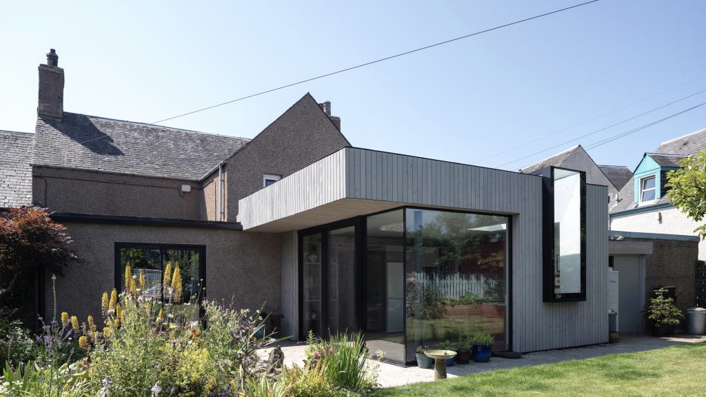 Timber clad extension with frameless corner glazing and frameless window and rooflight