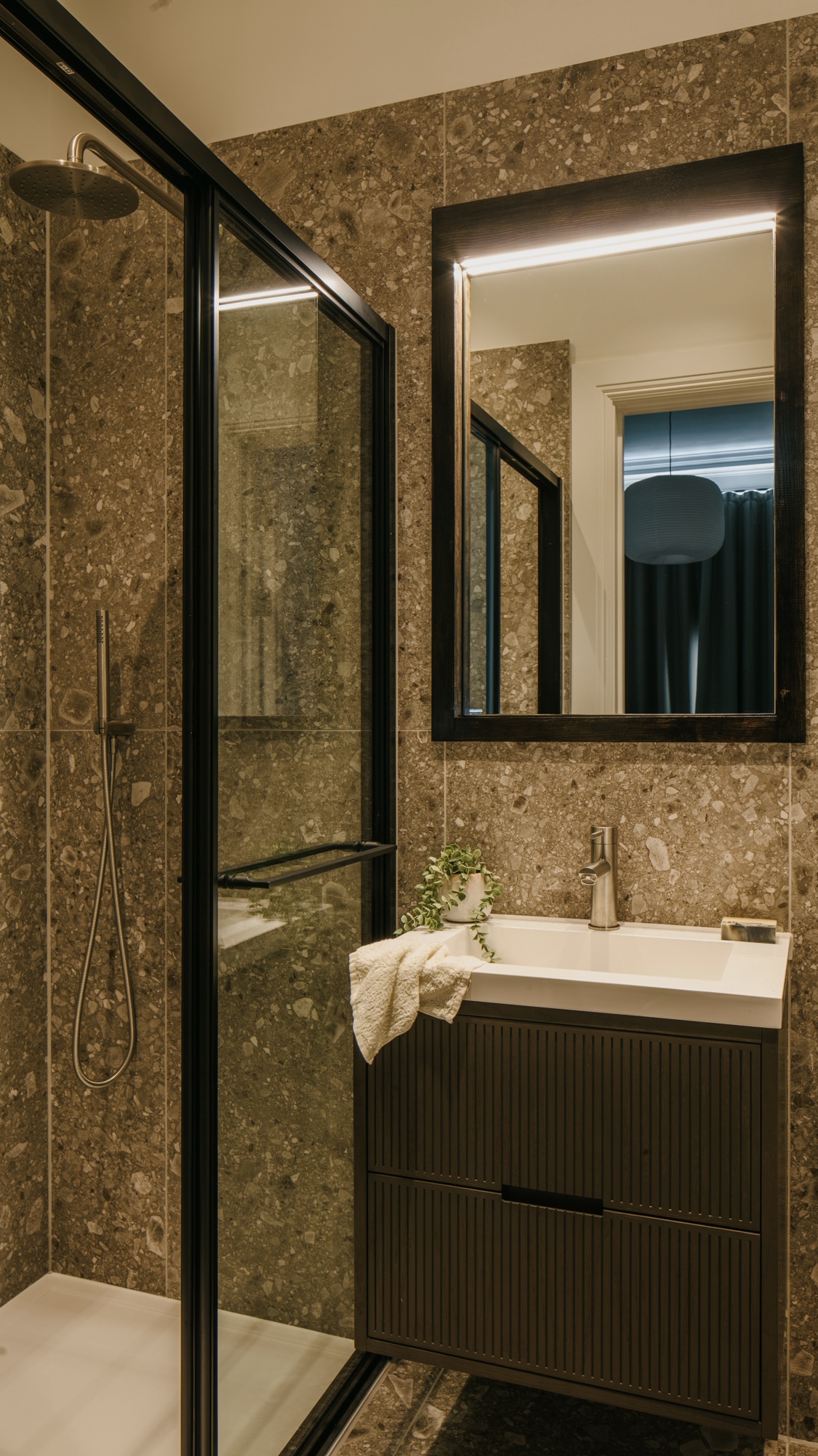 Contemporary bathroom with terrazzo style tiles and satin stainless steel brassware