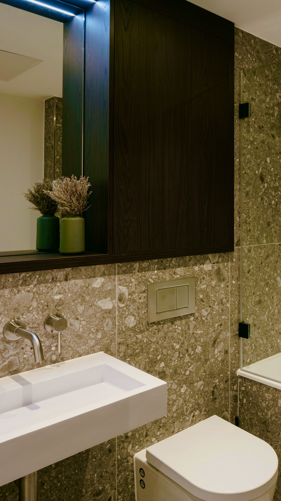 Contemporary bathroom with terrazzo style tiles and satin stainless steel brassware